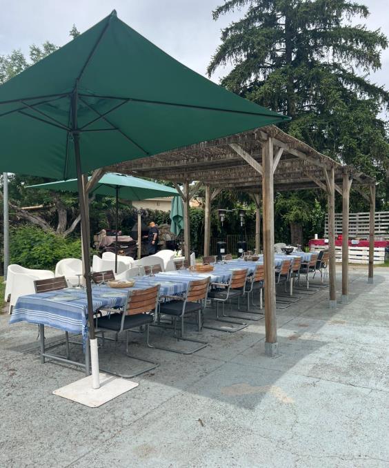 Mesas montadas al aire libre bajo sombrillas para un evento