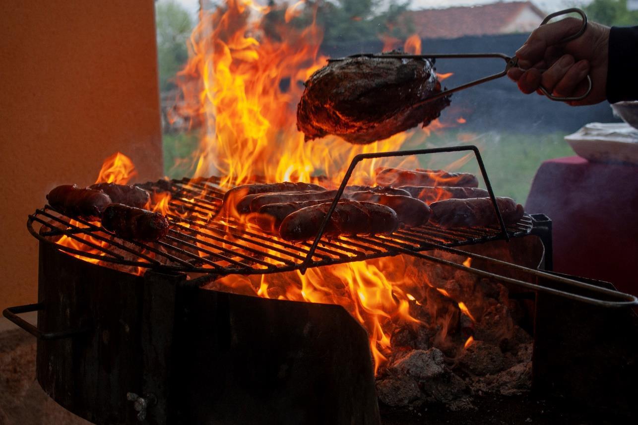 Carne a la brasa sobre una barbacoa con llamas